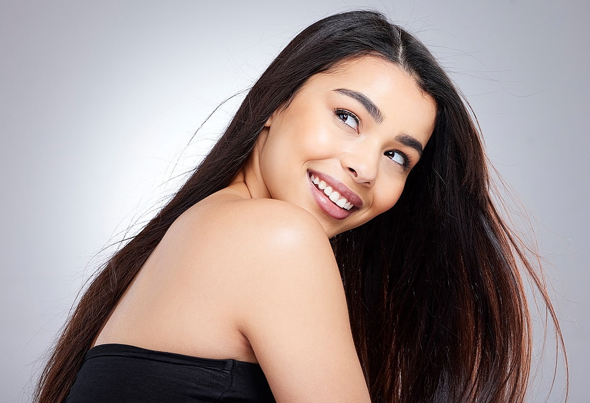 Smiling woman with long hair turned sideways.