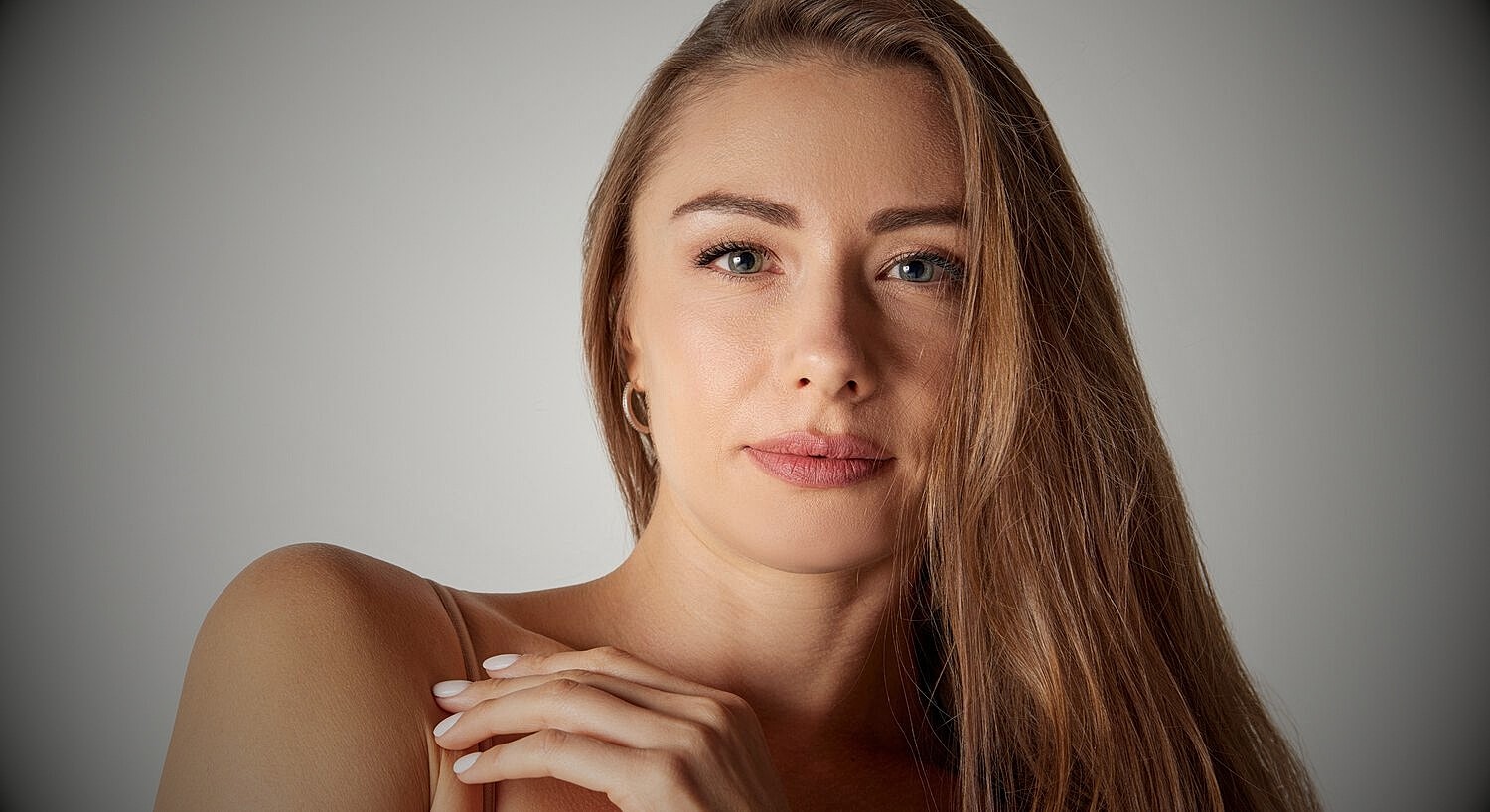Woman with long hair, looking directly at camera.