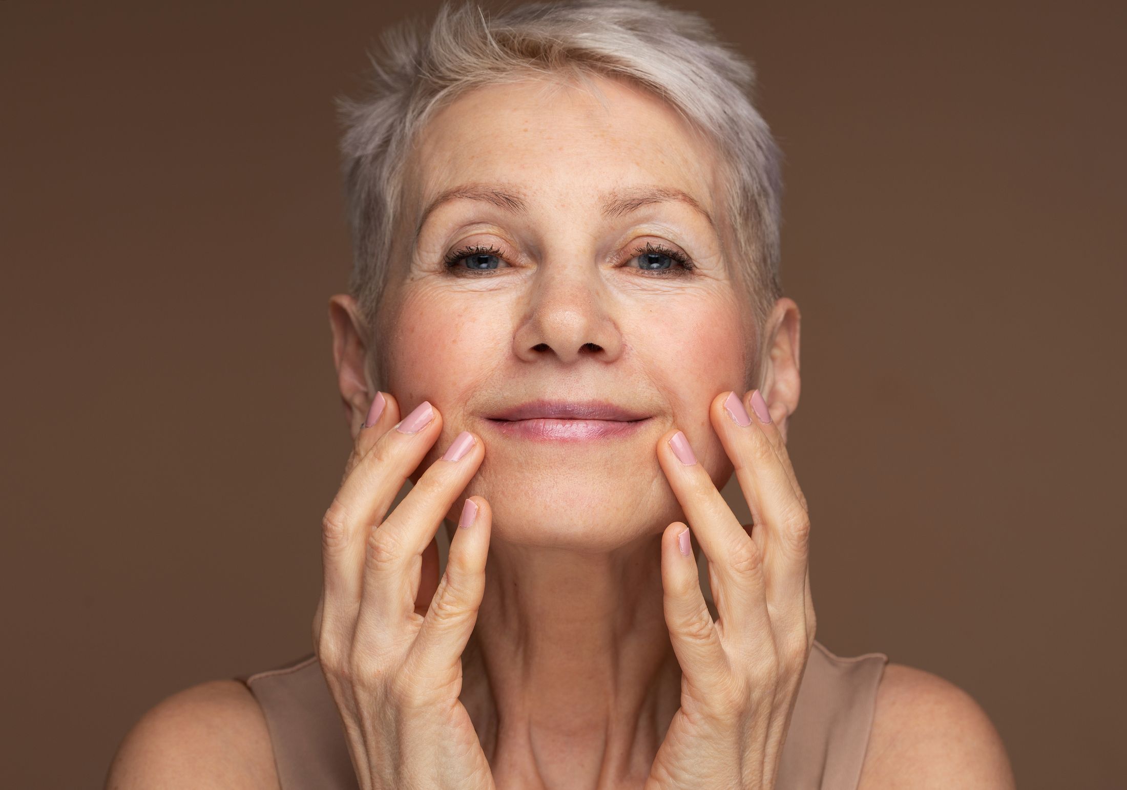 Woman smiling with hand on her face.